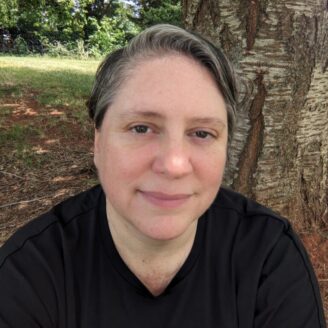 poet Julia Travel sitting in front of a tree